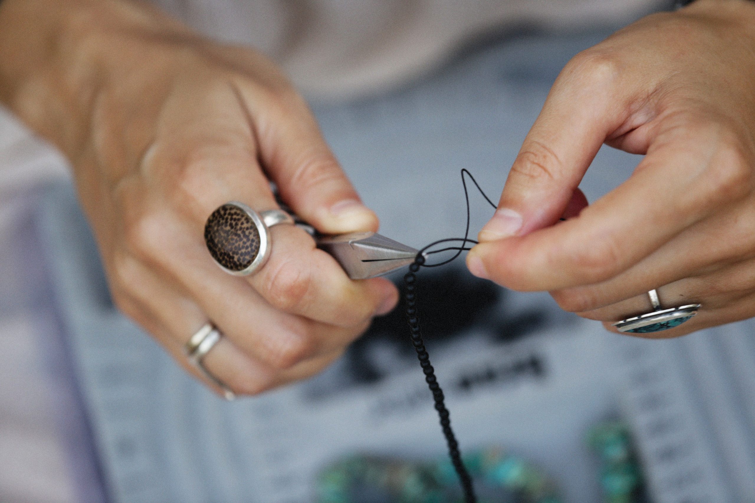 Mains créant bijoux tricotés avec perles et outils