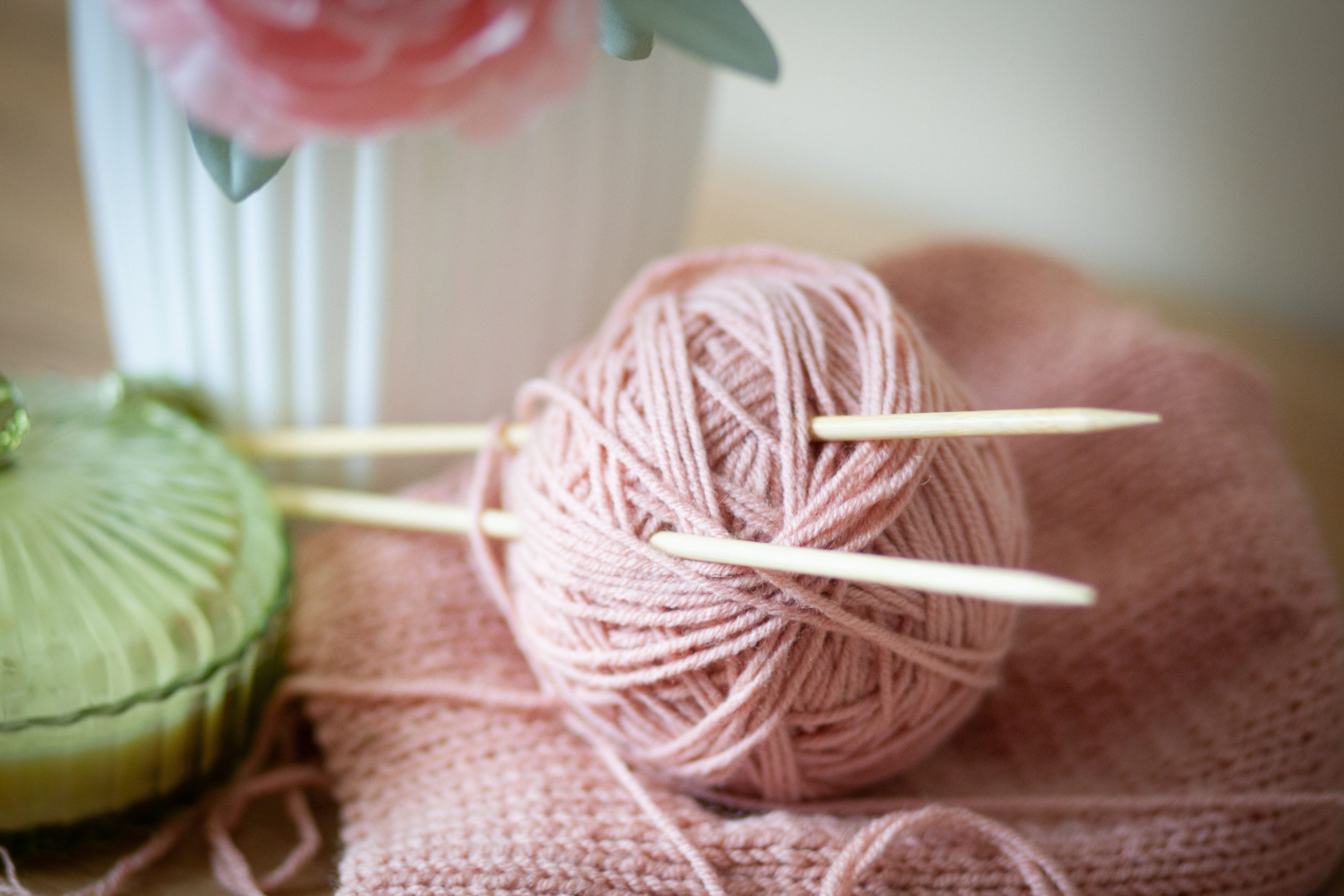 Fil rose pastel et aiguilles à tricoter