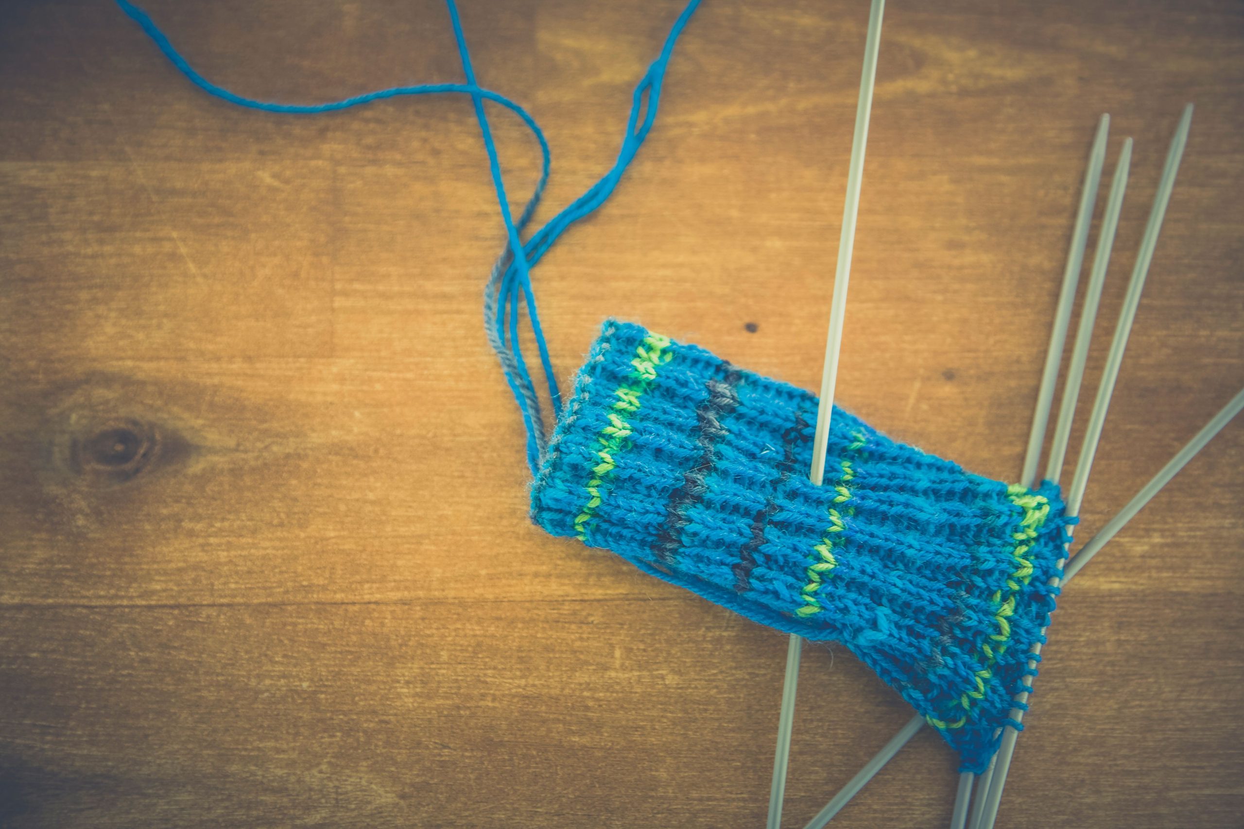 Projet tricot bleu et vert sur table bois