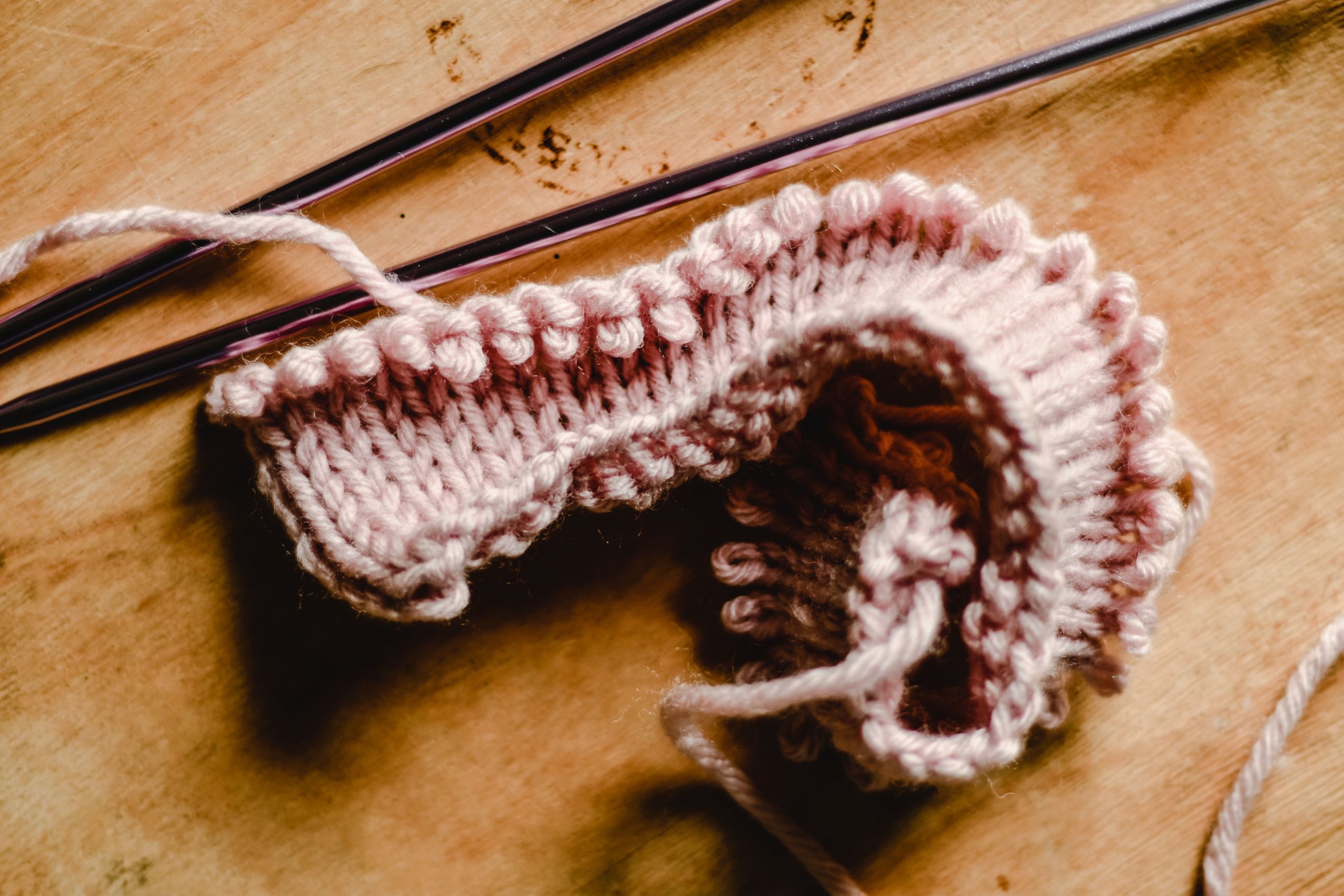 Projet tricot inachevé avec aiguilles sur table