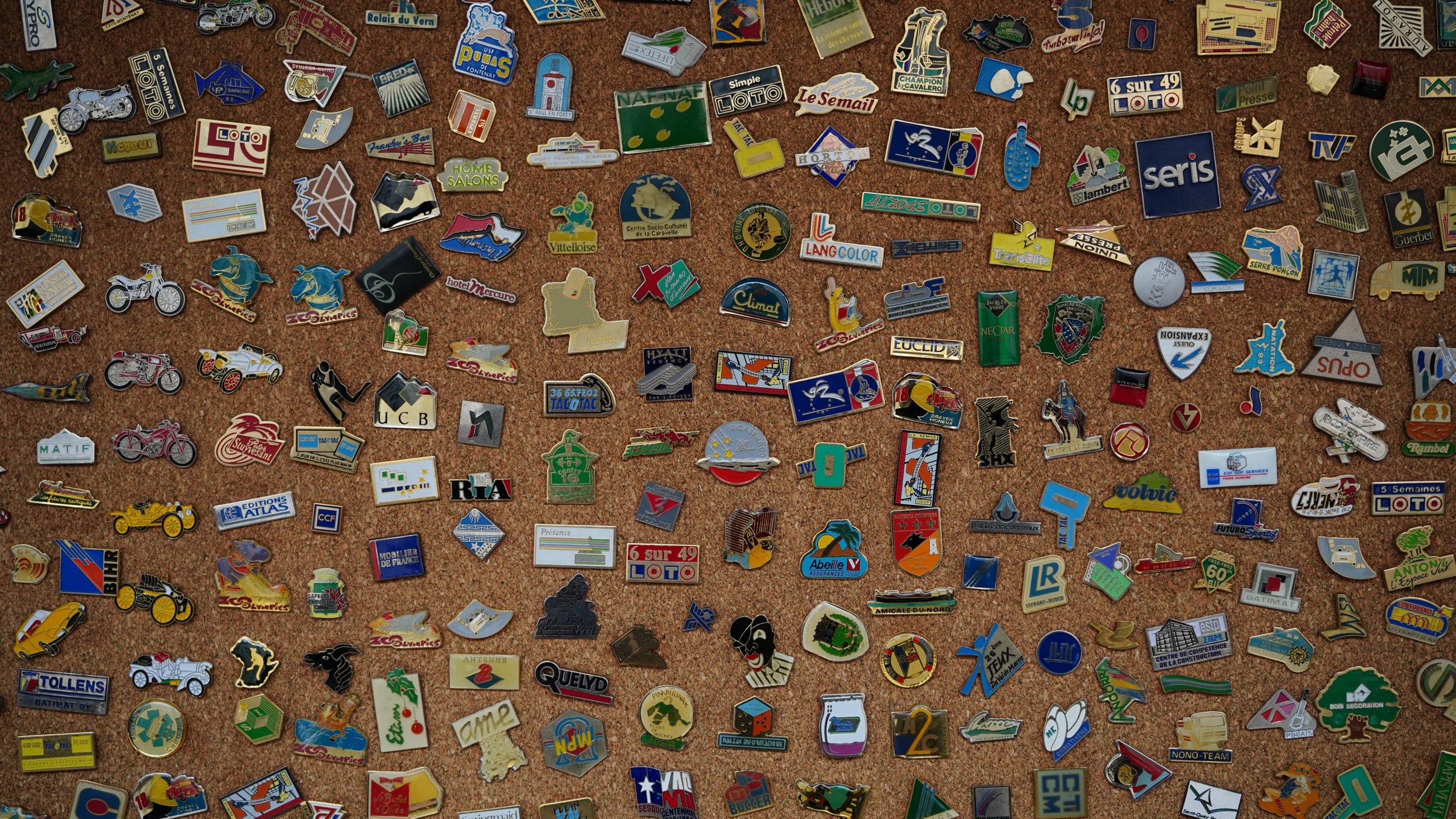 Collection diverse de pins vintage sur liège.
