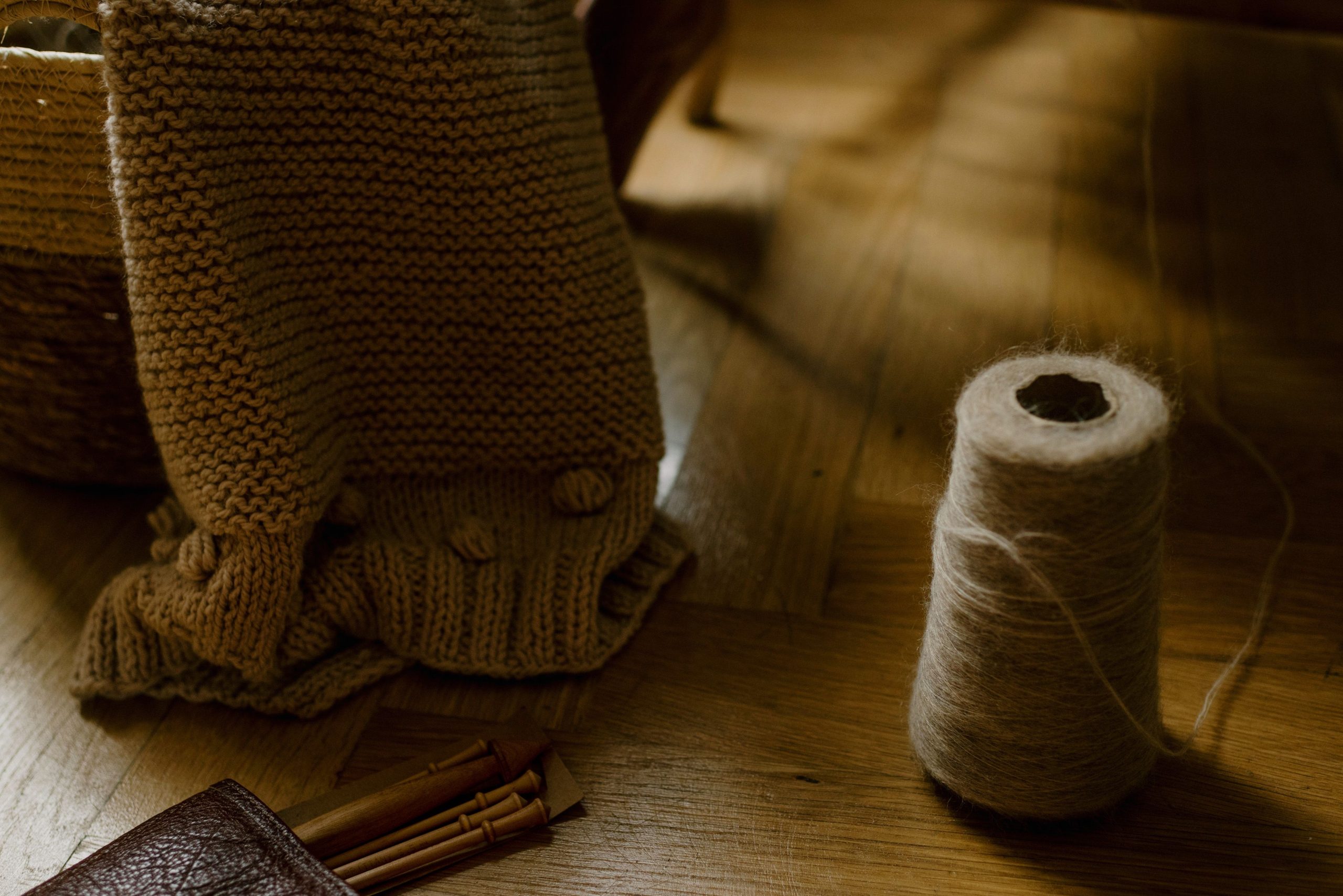 Couverture tricotee main dans panier avec aiguilles