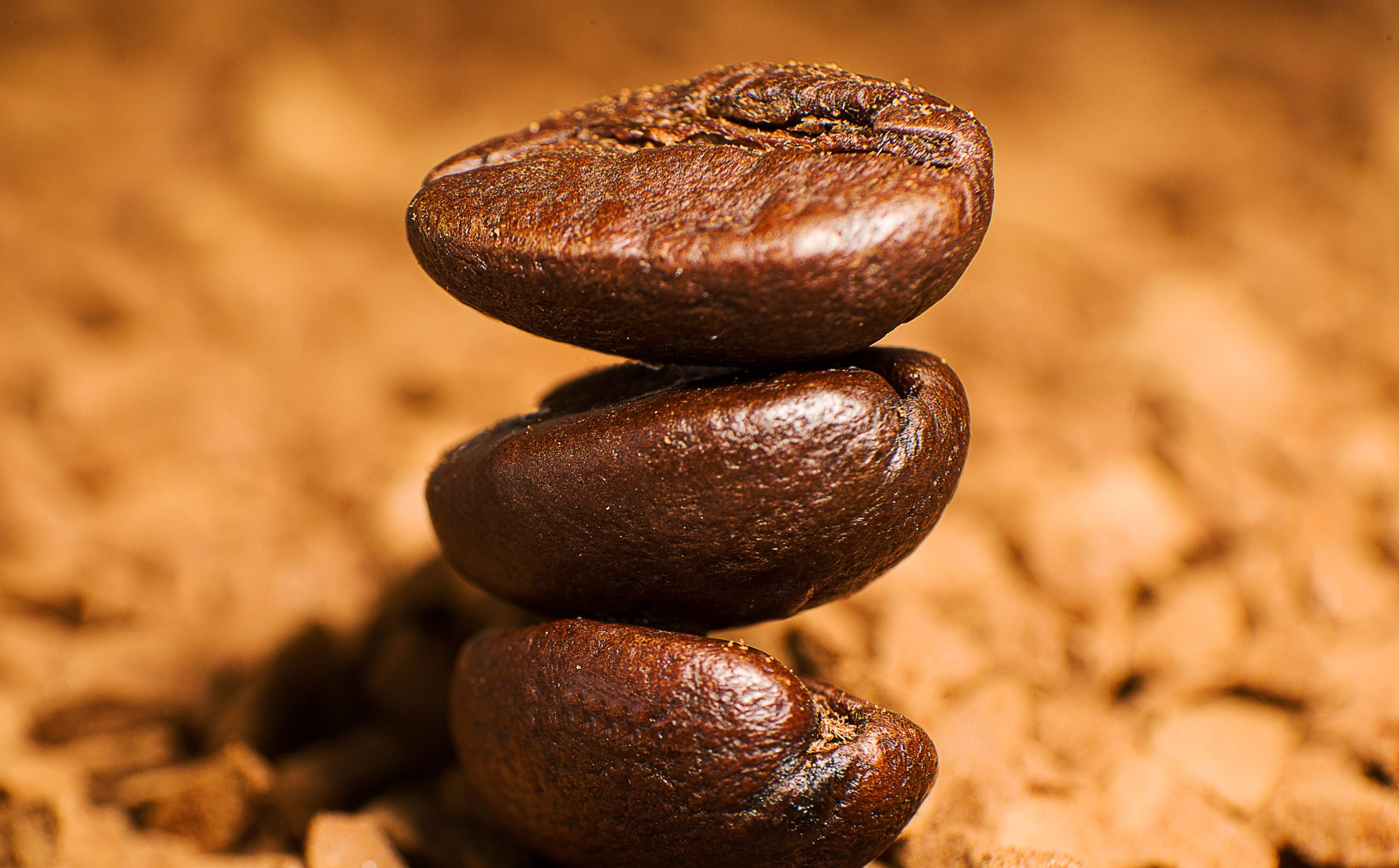 Grains de café rôtis empilés sur fond texturé