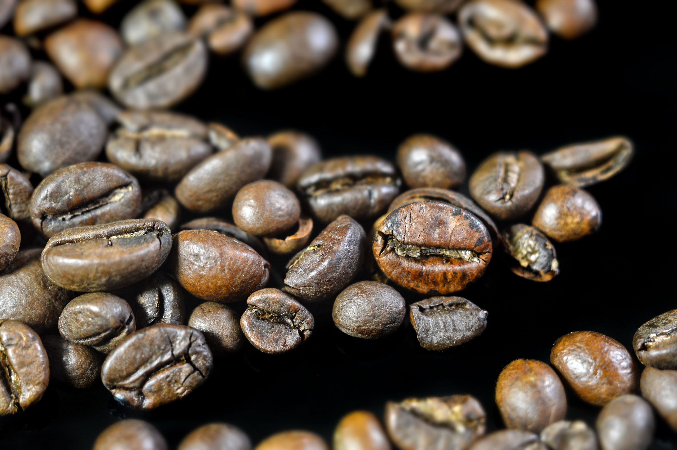Grains de café rôtis aromatiques sur fond noir