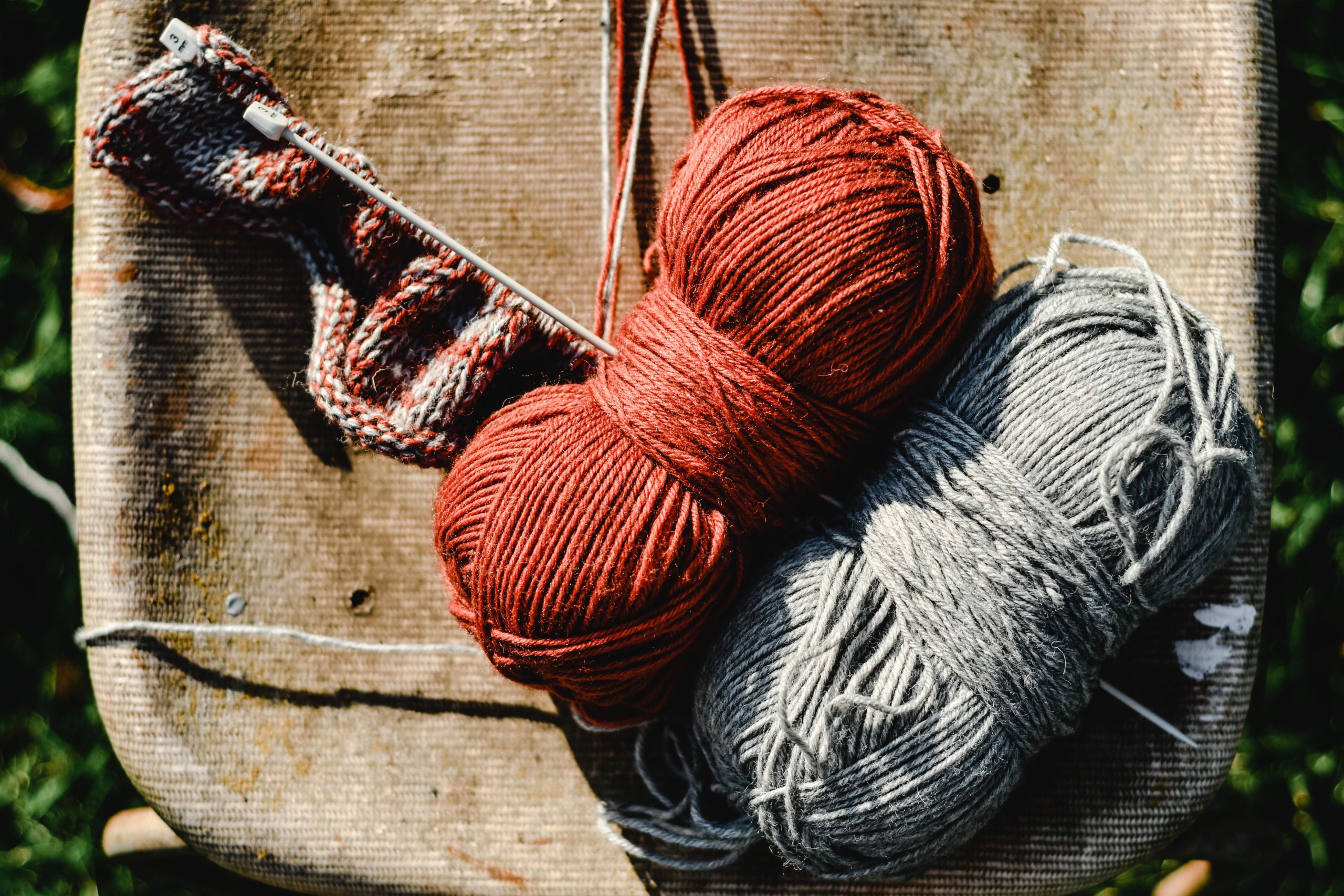 Pelotes de laine rouge et grise avec aiguilles tricot