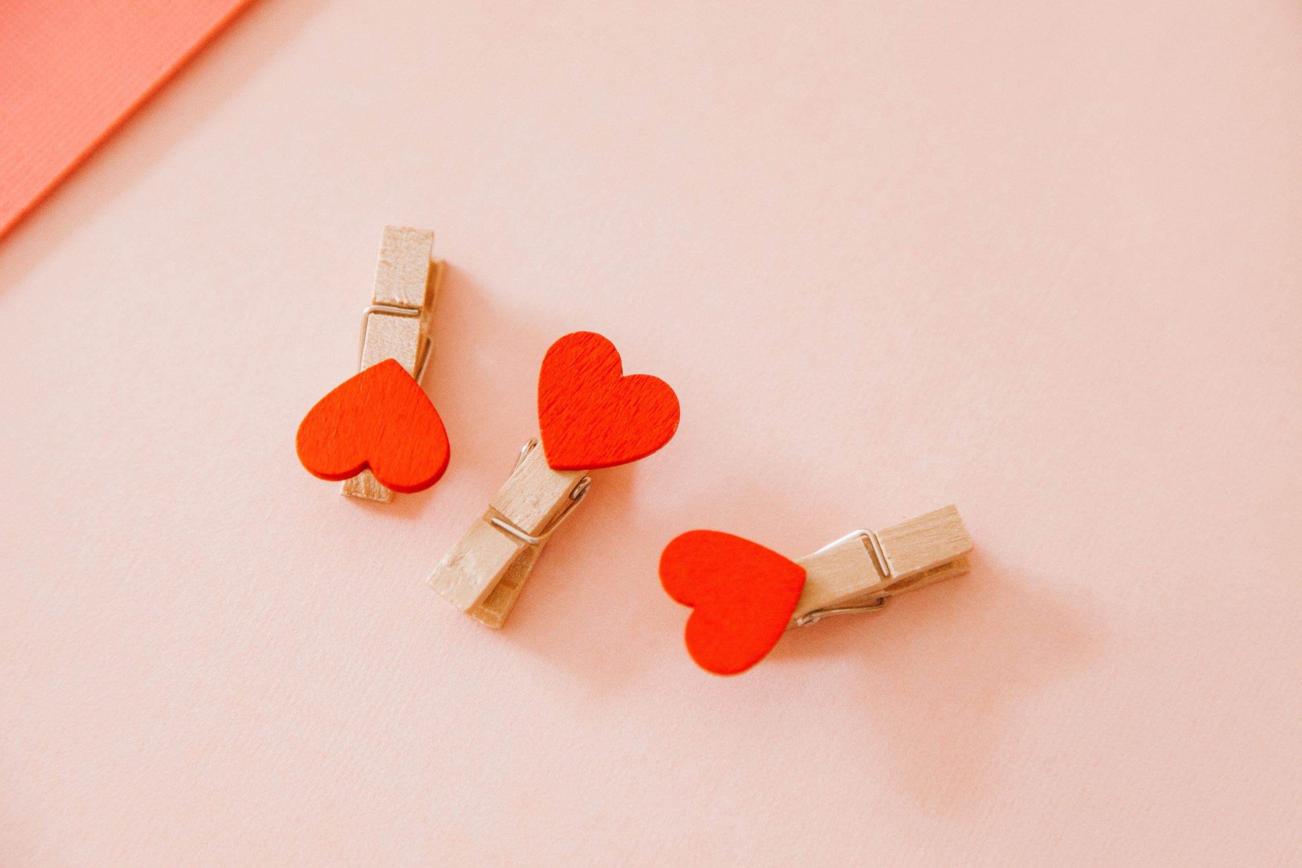 Pinces coeur en bois sur fond rose tendre