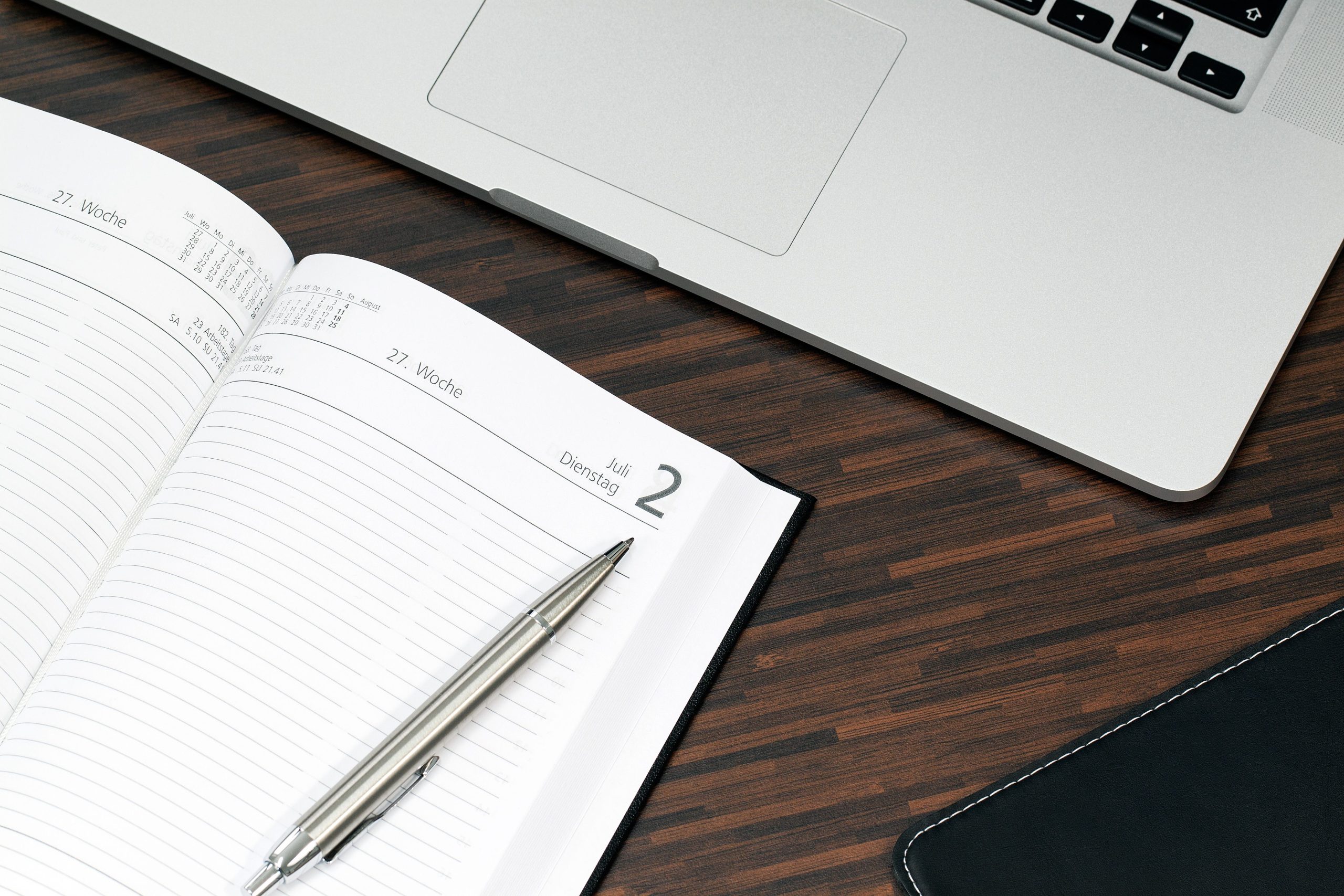 Agenda ouvert avec stylo et ordinateur sur un bureau