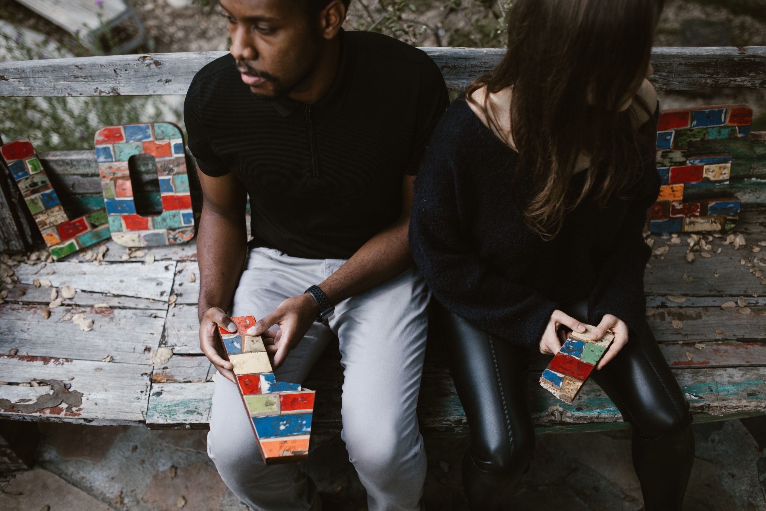 Couple sur banc avec blocs colorés formant le mot amour