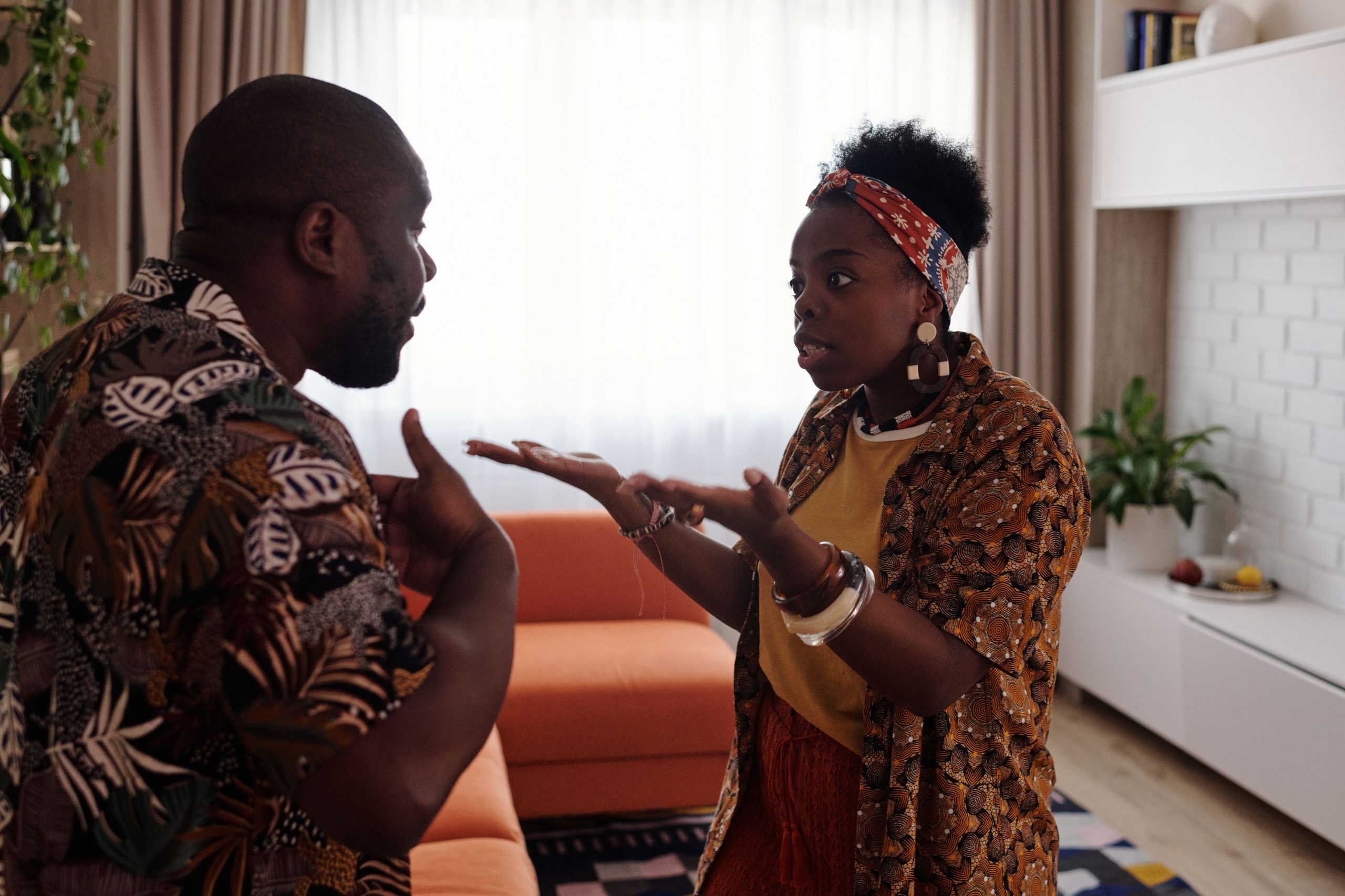 Couple argumentant passionnément au salon, gestes expressifs