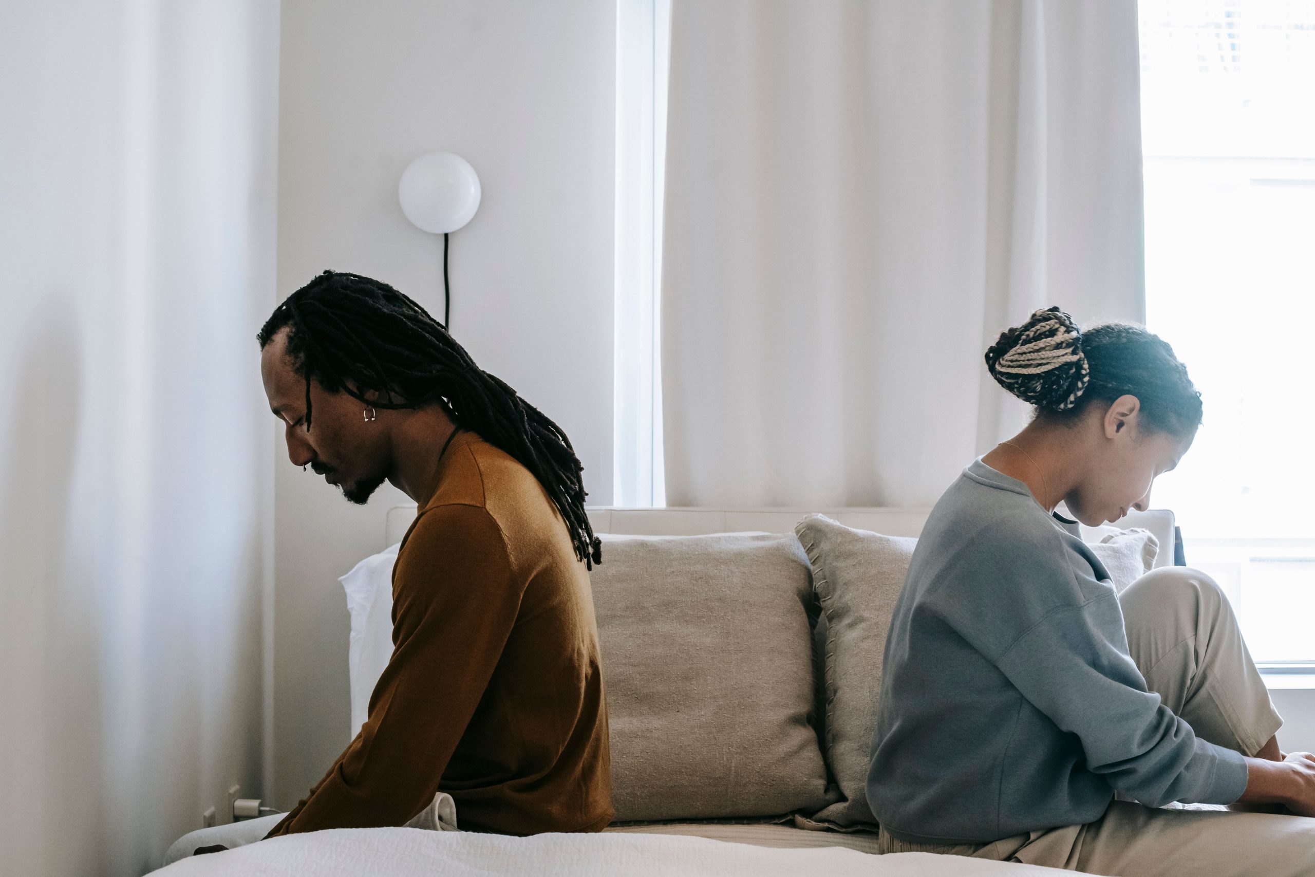 Couple africain malheureux assis dos à dos après dispute
