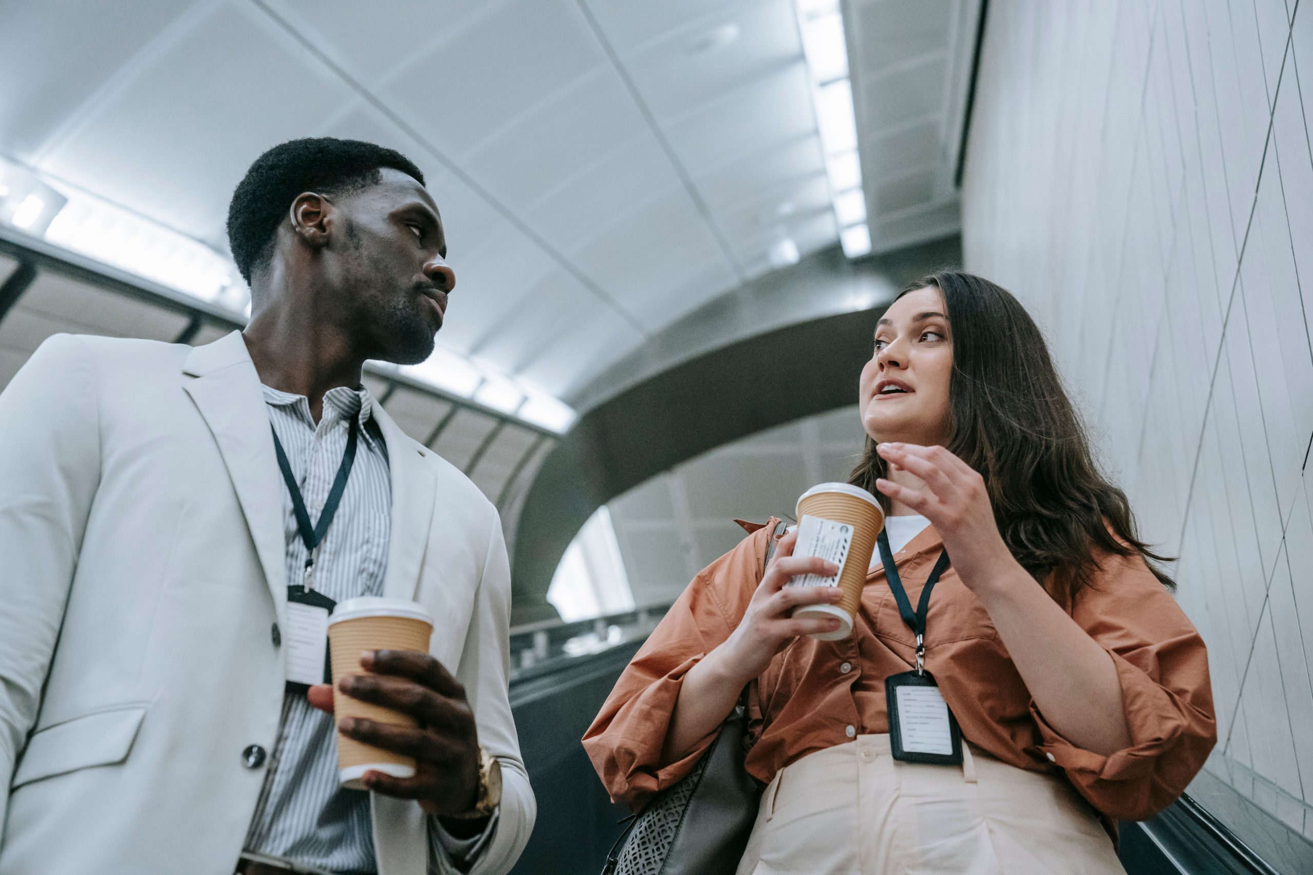Deux professionnels discutant decontractement escalator avec cafe