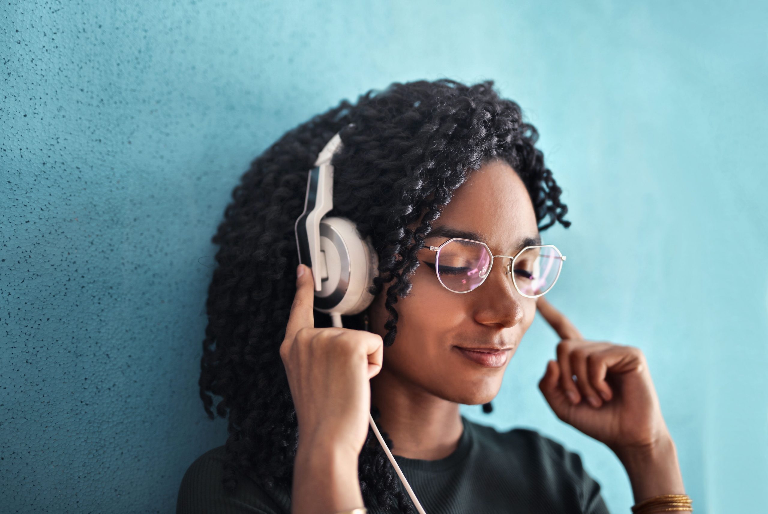 Femme aux cheveux bouclés écoutant musique relaxation