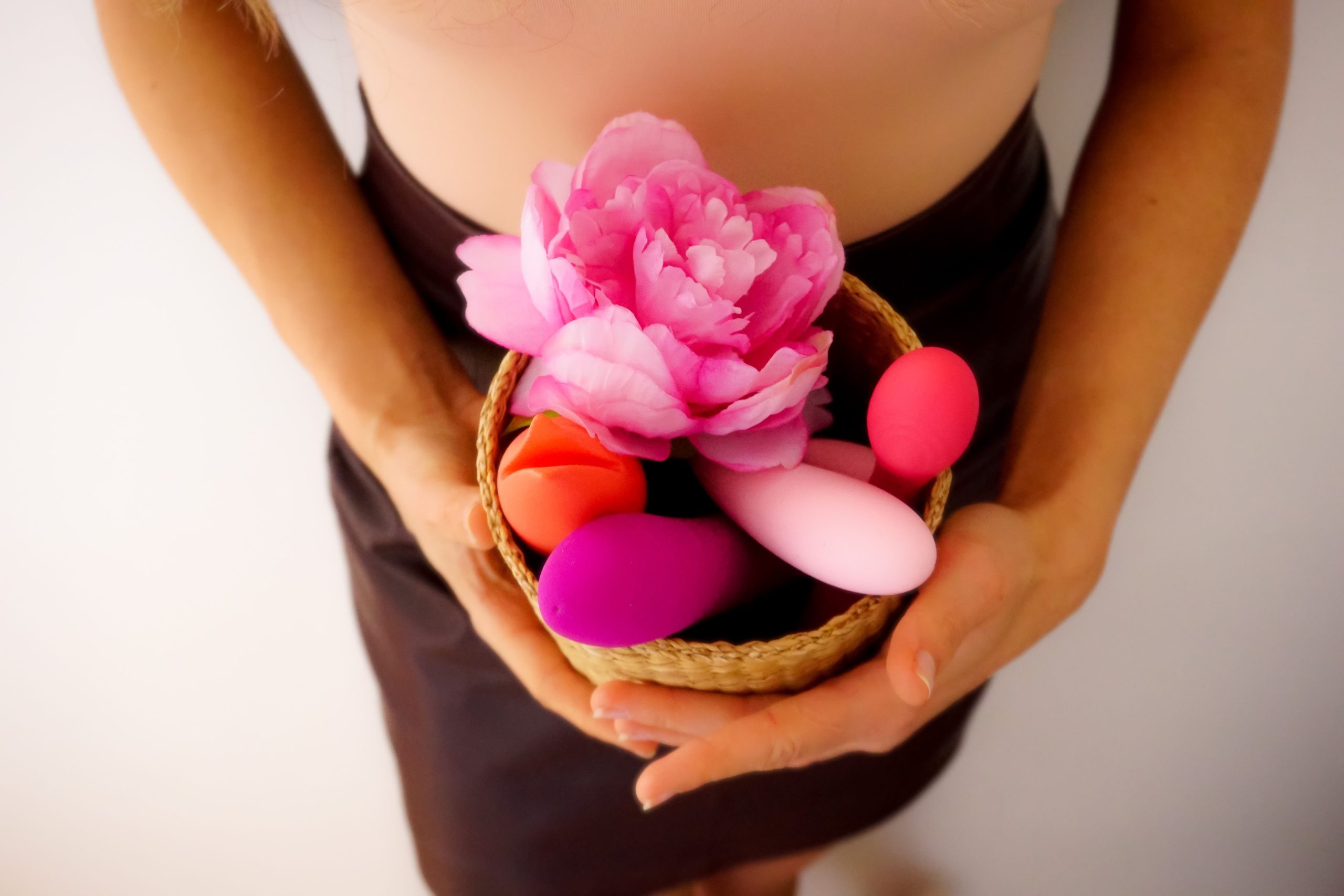Panier contenant des sextoys colores et une fleur