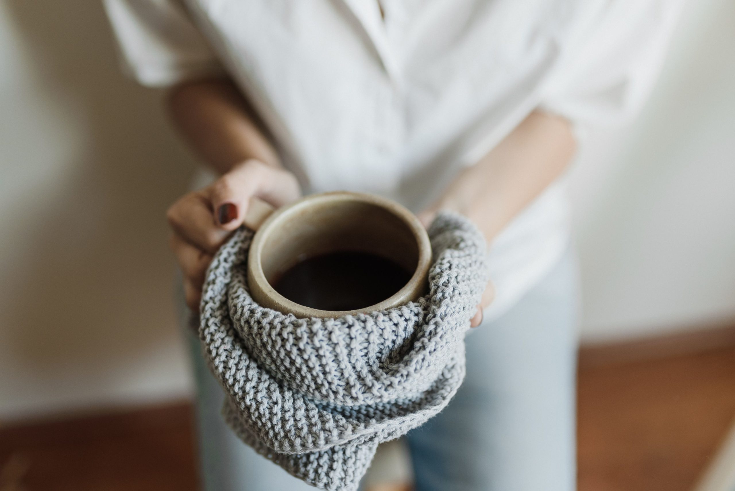 Mains tenant tasse tricotee echarpe laine interieur